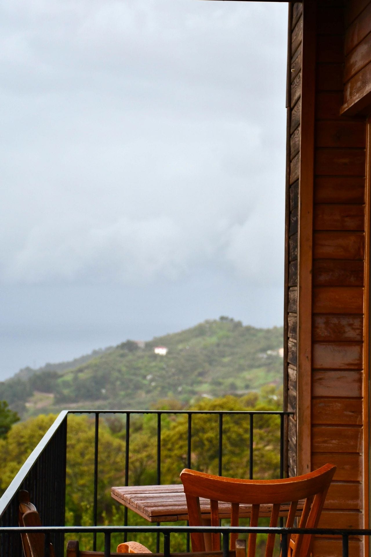 Varanda em madeira com cadeira e vista sobre montanha — perspetiva e análise